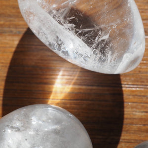 Two Clear Quartz Yoni Eggs on Wooden Background 